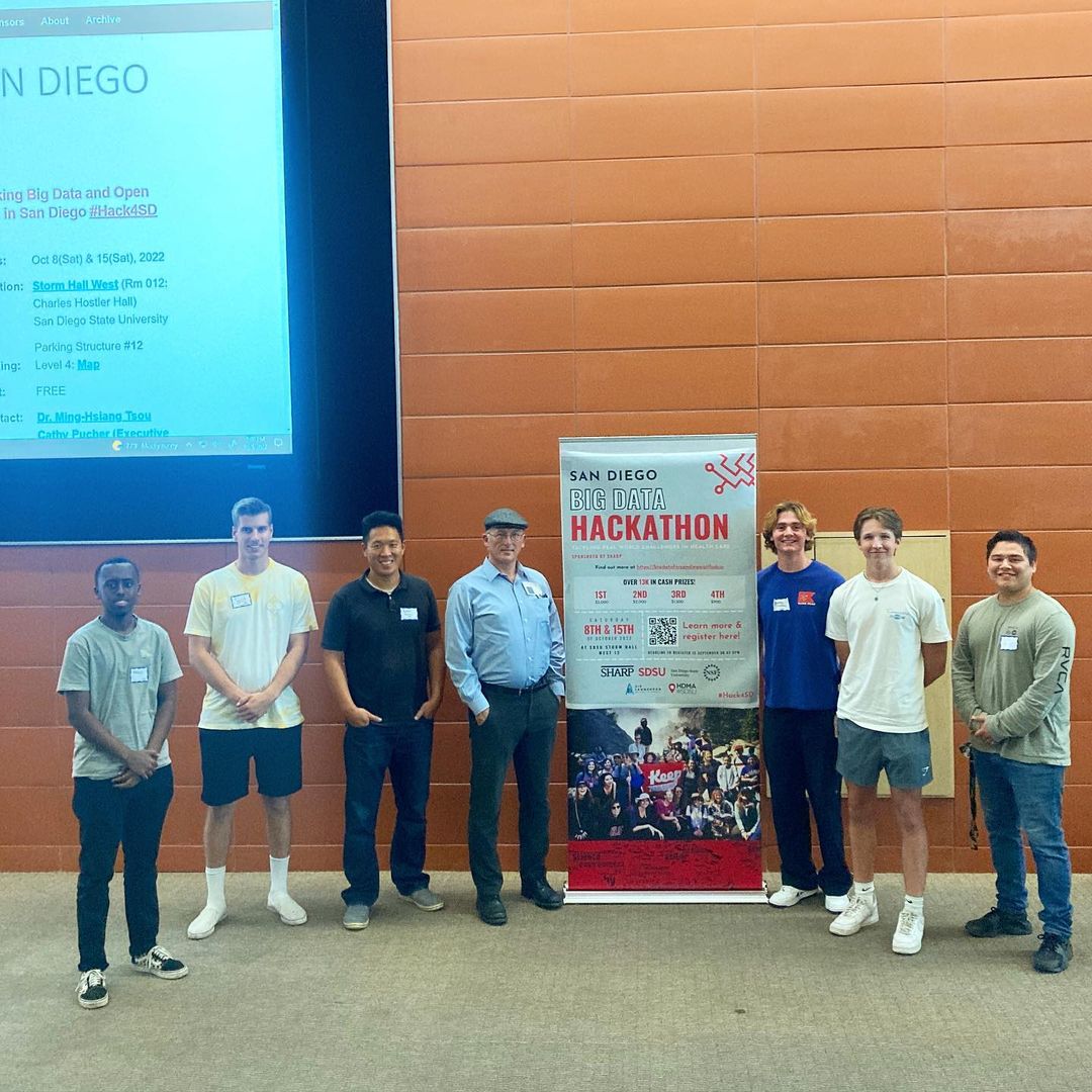 SDCS members posing near the San Diego Big Data Hackathon signage